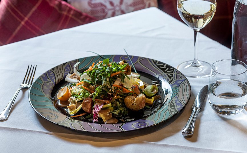 DAS UNTERRAIN lifestyle hotel **** © Charme Hotels Osttirol GmbH Salat mit Garnelen auf kunstvollem Teller neben Gläsern und Besteck