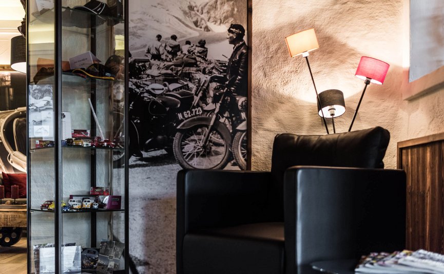 Vötter's Hotel **** © makeART OG Gemütlicher Bereich mit schwarzem Ledersessel und Vintage-Motorradfoto an der Wand