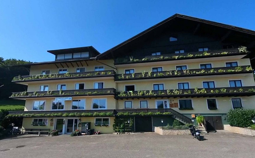 Gast-Hof-Laden Schneeweiss *** © Gast-Hof-Laden Schneeweiss Großes uriges Chalet mit Balkonpflanzen bei klarem Himmel