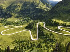 Nockalmstraße © Land Kärnten - Nockalmstraße - Großglockner Hochalpenstraßen AG Kurvige Bergstraße durch grüne Landschaft und Hügel