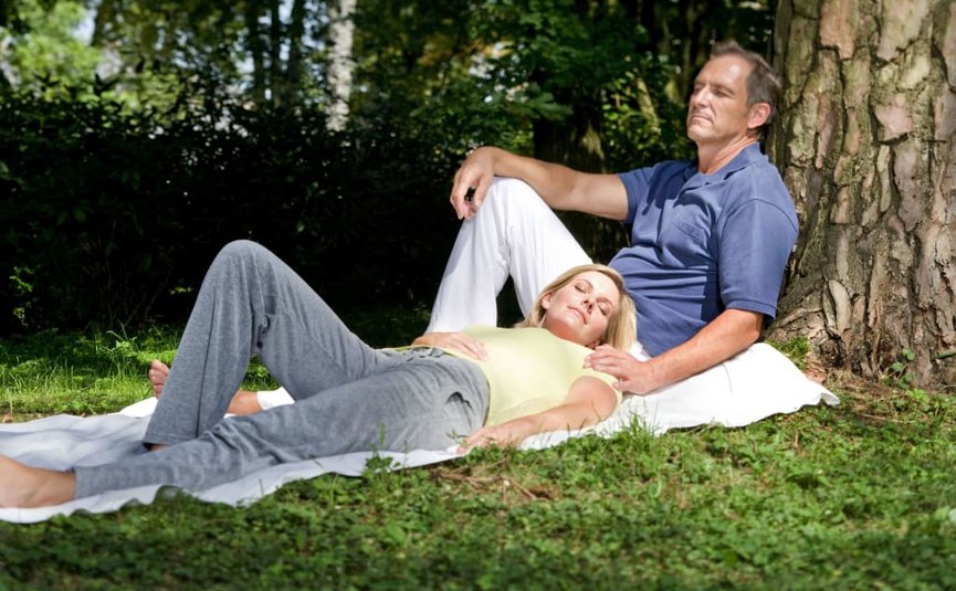 Hot Deal 5= 4 Paar entspannt auf Decke im Park neben Baum