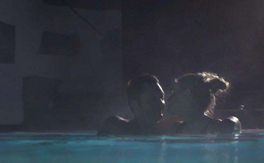Babymoon im Hotel Rockenschaub Paar umarmt sich im Schwimmbad bei Nacht