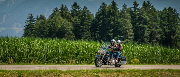 3 Zinnen – Kronplatz – Eisacktal © Moppetfoto.de Zwei Motorradfahrer fahren auf Landstraße vor Wald und Bergen