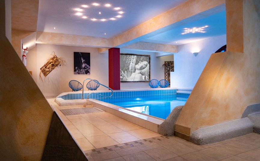 Vötter's Hotel **** © Nikolaus Faistauer Innenpoolbereich mit stilvoller Beleuchtung und Fotokunst an den Wänden