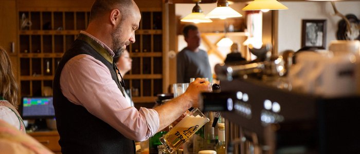 Mann schenkt Bier in einem traditionellen Gasthaus ein