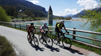Central goes Gravel!
 © Verena Stitzinger Drei Radfahrer fahren am Reschensee mit versunkenem Kirchturm im Hintergrund