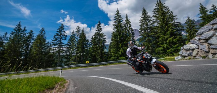 Hochkönig © Moppetfoto.de Motorradfahrer auf kurviger Bergstraße vor Nadelbäumen und blauem Himmel