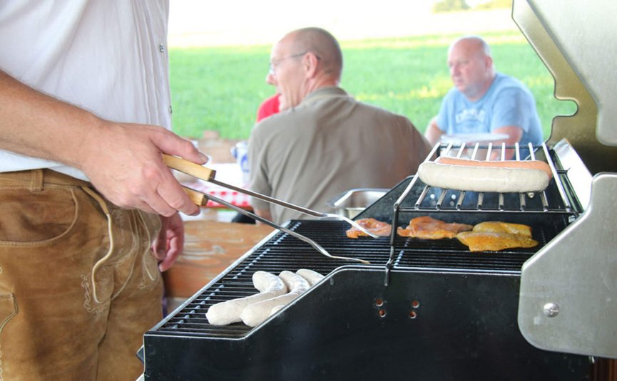 Hotel Bergblick © Hotel Bergblick Person grillt Würste und Fleischstücke auf dem Grill im Freien