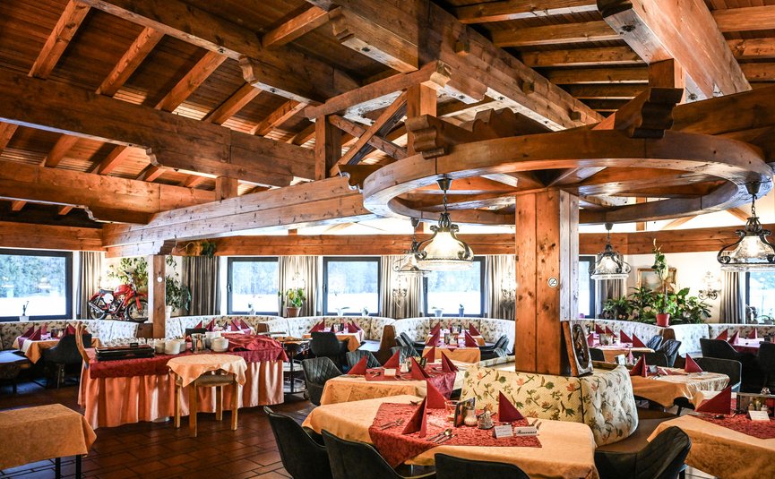 Rustikales Restaurant mit Holzbalkendecke und festlich gedeckten Tischen