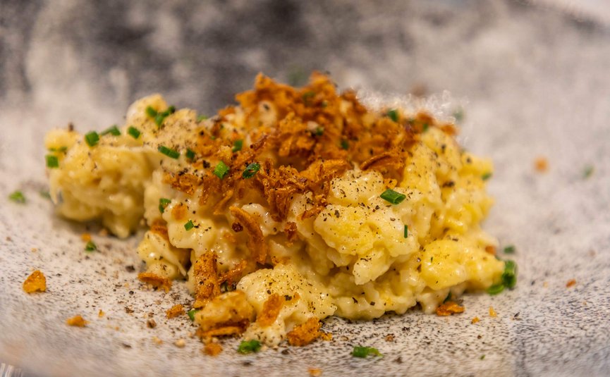 Käse-Spätzle mit Röstzwiebeln und Schnittlauch auf einem Teller
