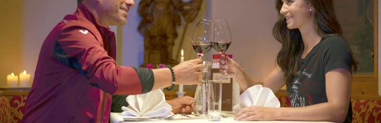 Kulinarische Reise durchs Wald- und Mühlviertel Ein Mann und eine Frau stoßen beim romantischen Abendessen mit Rotwein an