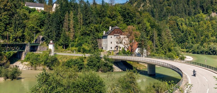 Gast-Hof-Laden Schneeweiss *** © Alexander Seger Kurvenreiche Brücke über Fluss bei Haus und Wald am sonnigen Tag