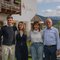 Familienfoto vor einem Haus mit Bergen im Hintergrund