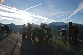 4 Touren Bike Woche Motorradfahrer mit Motorrädern auf Bergstraße bei Sonnenuntergang