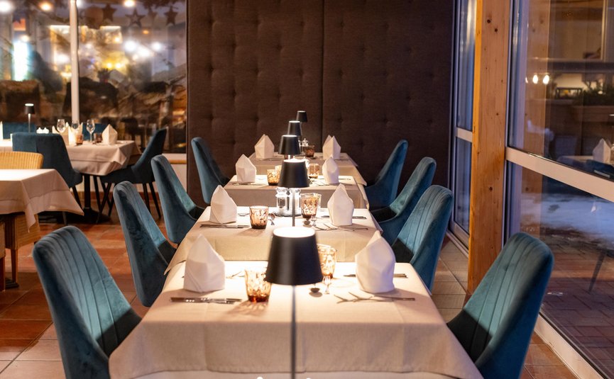 Vötter's Hotel **** © Nikolaus Faistauer Eleganter Tisch mit blauem Stuhl und eingedecktem Tisch im Restaurant