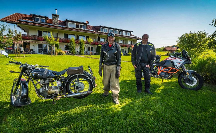 Hotel Bergblick © Moppetfoto.de Zwei Männer mit Vintage- und modernen Motorrädern auf einer Wiese vor einem Haus