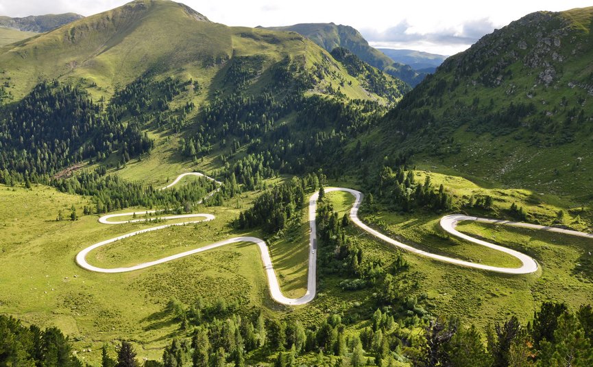 Motorradurlaub im Mölltal – Großglockner – Nockalm © Land Kärnten - Großglockner Hochalpenstraßen AG Serpentinenstraße in grünen, bewaldeten Bergen bei Tageslicht