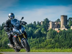 Mühlviertel © Moppetfoto.de Motorradfahrer auf Landstraße vor bewaldetem Hügel mit Burgruine