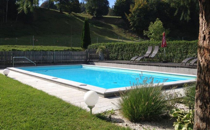 Gast-Hof-Laden Schneeweiss *** © Gast-Hof-Laden Schneeweiss klare outdoor-pool mit liegestühlen und hügeliger waldlandschaft