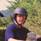 Mann mit Helm auf blauem Harley-Davidson Motorrad im Garten