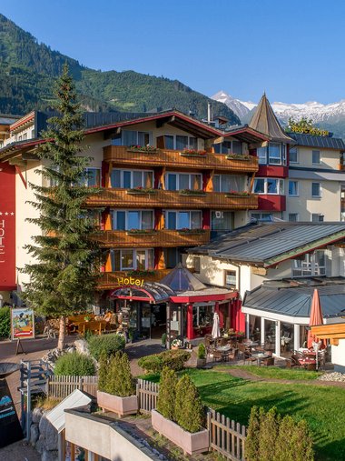 Hotel in den Alpen mit Bergen im Hintergrund und blauen Himmel