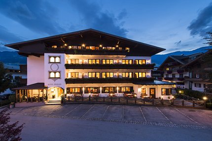 Hotel DER PINZGER © multi visual ART Beleuchtetes Hotelgebäude am Abend in den Bergen