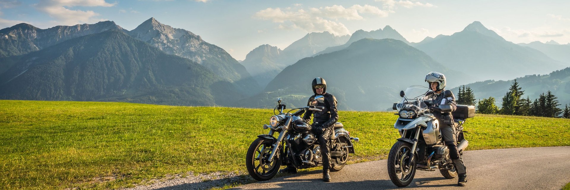 Ferienregion Wolfsberg – Region Lavanttal © Moppetfoto.de Zwei Motorradfahrer auf Landstraße mit grünen Wiesen und Alpen im Hintergrund