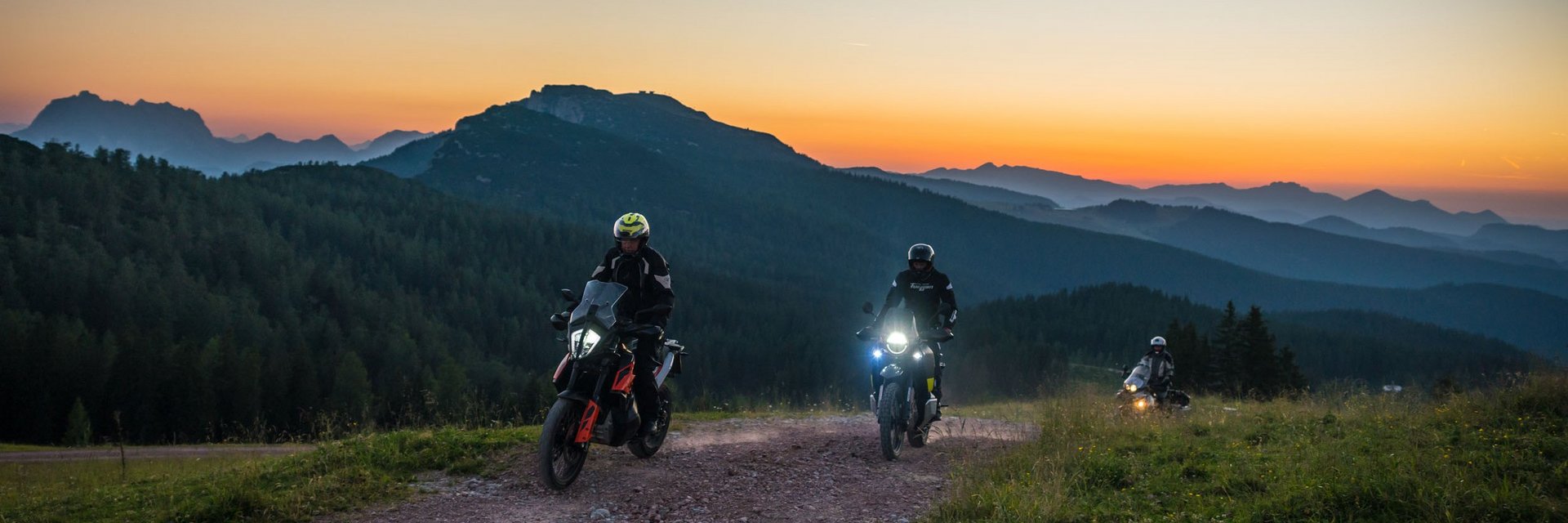 Niedere Tauern – Nockalm © Moppetfoto.de Drei Motorradfahrer fahren auf einem Bergweg bei Sonnenuntergang