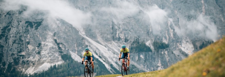Prädikat: Außergewöhnlich © Jens Scheibe Zwei Radfahrer fahren auf einem Bergweg vor nebligen Alpenfelsen