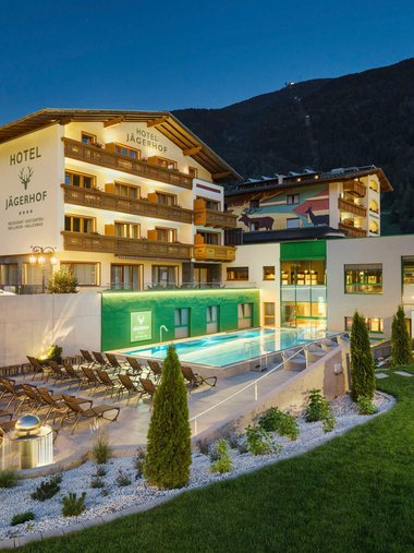 Motorradurlaub © Florian Scherl Hotel Jägerhof mit beleuchtetem Außenpool und Liegestühlen bei Nacht