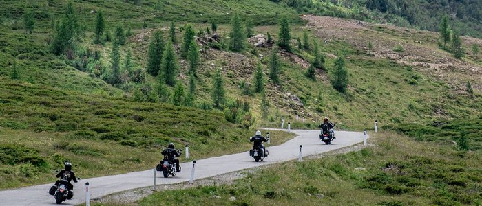 Osttirol – Großglockner – Lienzer Dolomiten © Armin Kleinlercher Vier Motorräder fahren auf Bergstraße mit Nebel und grünen Hängen
