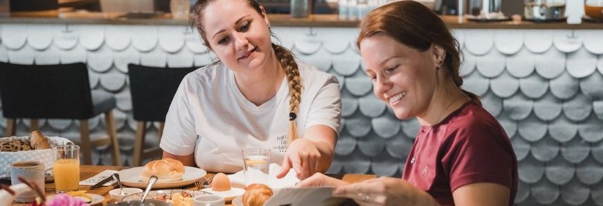 Gravelbikeurlaub im Hotel Rössle
 © Nussbaumer Photography Zwei Frauen beim Frühstück und Lesen in einem Magazin im Café
