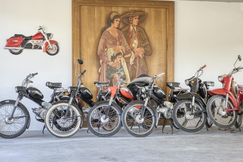 🛵2-Wheeler-Midweek🏍️ Sammlung alter Motorräder vor einem Wandbild mit einer Familie