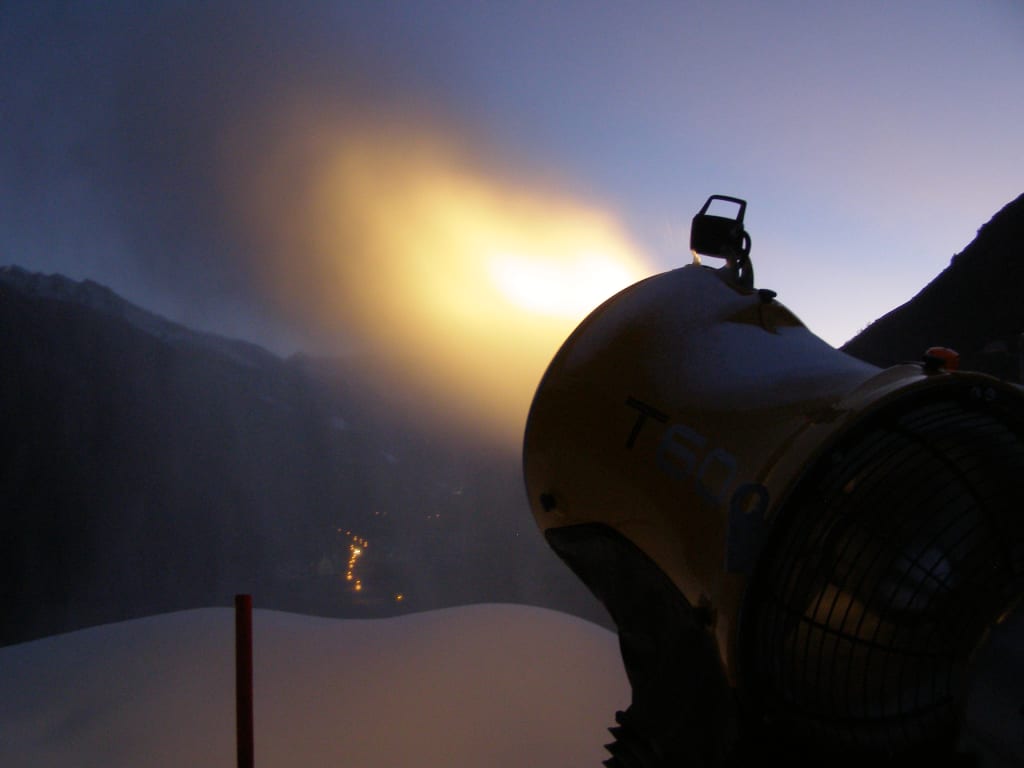 Skiopening 4 Tage - Sonntagsanreise Schneekanone produziert Schnee bei Dämmerung in den Bergen