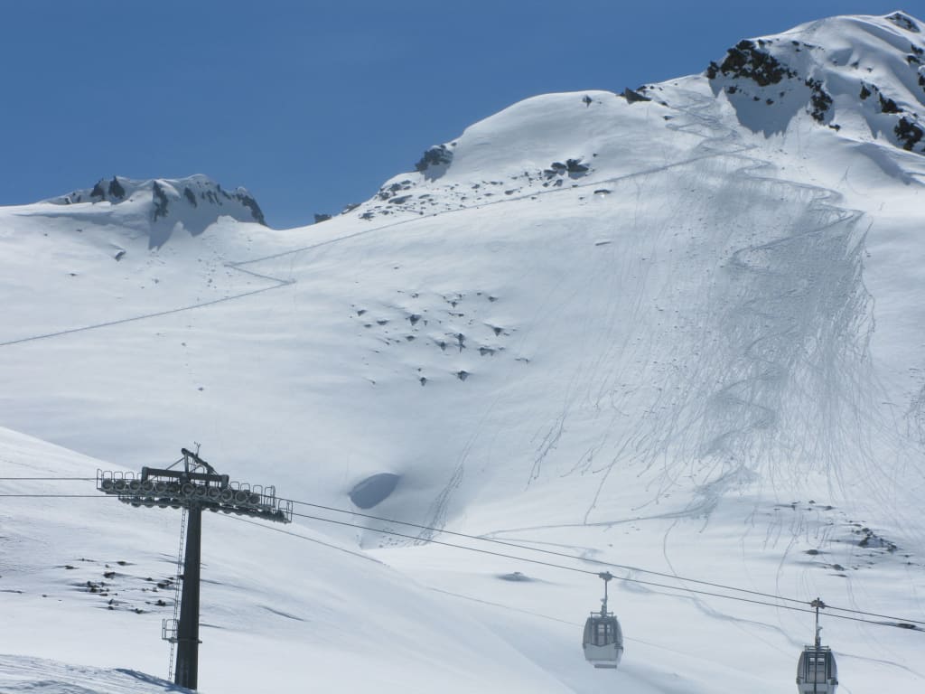 Skiopening 3 Tage - Sonntagsanreise Seilbahn und schneebedeckte Alpen mit Skispuren unter blauem Himmel