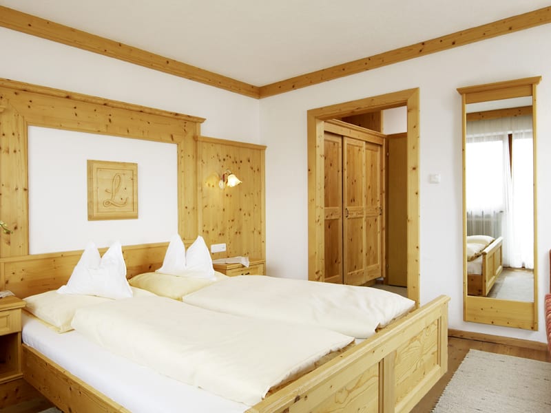 Firn Schnee Pauschale Hell eingerichtetes Schlafzimmer mit Holzmöbeln und Doppelbett