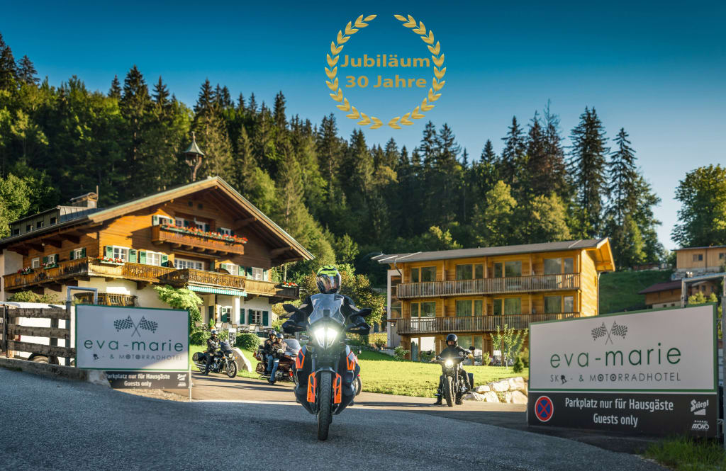 Motorradfahrer vor Hotel Eva-Marie im Wald mit Jubiläum 30 Jahre