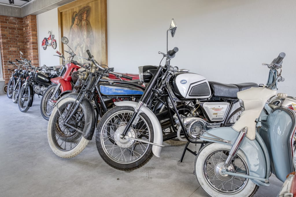 Motorrad & Vespa Weekend Reihe verschiedener alter Motorräder in einer Halle