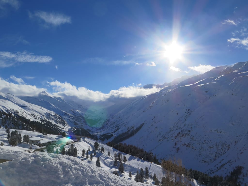 Skiweltcup 4-Tg. Sonniger Tag in einem schneebedeckten Tal mit Bergen und Bäumen