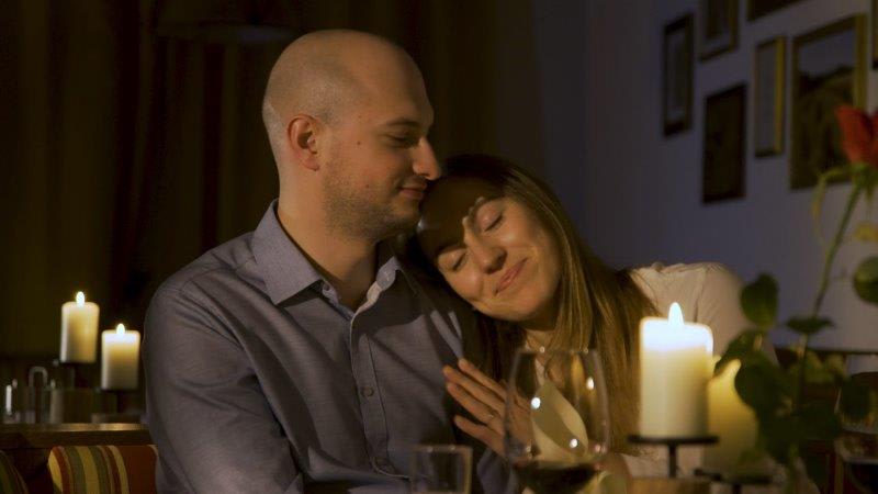 Paar genießt romantisches Candle-Light-Dinner mit Kerzenlicht und Wein